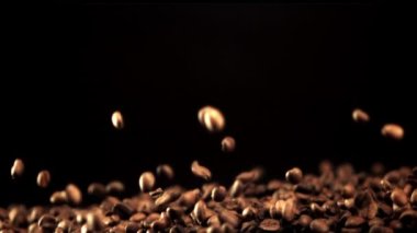 Süper yavaş kahve çekirdekleri yukarı çıkar ve düşer. 1000 fps hızla yüksek hızlı bir kamerayla çekildi..