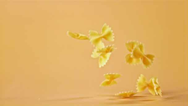 Super zpomalené těstoviny farfalle padá na stůl. Natočeno na vysokorychlostní kameře rychlostí 1000 snímků za sekundu. — Stock video