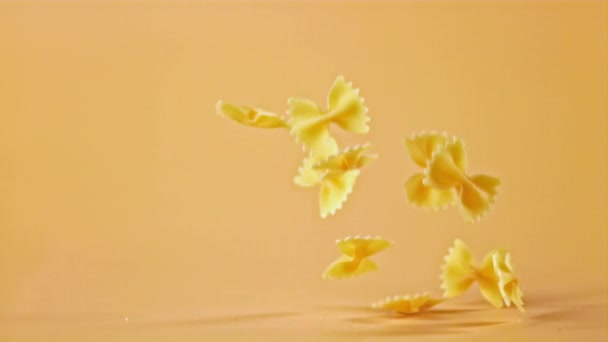 Nudelfarfalle in Superzeitlupe fällt auf den Tisch. Gefilmt mit einer Hochgeschwindigkeitskamera bei 1000 fps. — Stockvideo