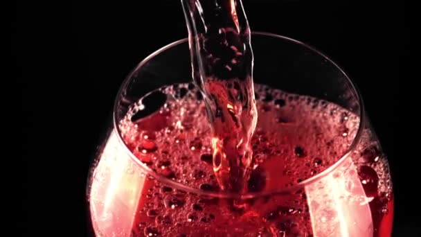 Un chorro de vino tinto en cámara súper lenta se vierte en un vaso de burbujas de aire. — Vídeo de stock