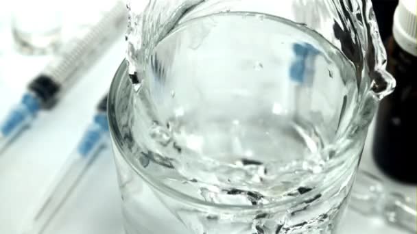 Le comprimé tombe dans un verre d'eau avec des éclaboussures. Filmé au ralenti 1000 images par seconde. — Video