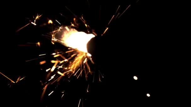 Brillantes chispas del fuego de Año Nuevo en Bengala sobre un fondo negro. Filmado en cámara lenta 1000 fps. — Vídeos de Stock