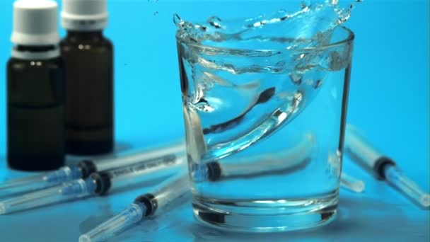 Un comprimé avec éclaboussures tombe dans un verre d'eau. Filmé est au ralenti 1000 ips. — Video