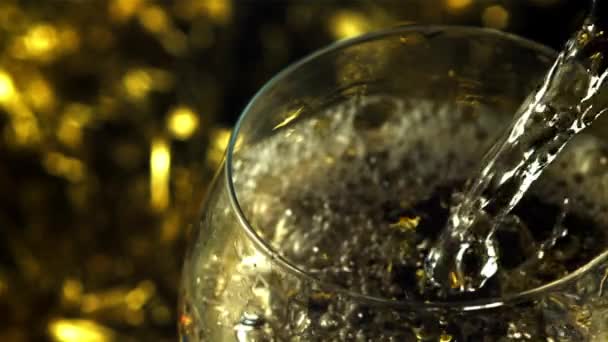 Champagner ergießt sich in ein Glas mit Spritzern und Luftblasen. Gefilmt wird Zeitlupe 1000 fps. — Stockvideo