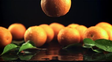 Sulu bir mandalina masaya su damlatarak düşer. Saniyede 1000 kare yavaş çekimde çekiliyor..