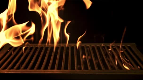 En flammende flamme brenner gjennom grillen. Filmet er en langsom bevegelse 1000 bilder per sekund.. – stockvideo