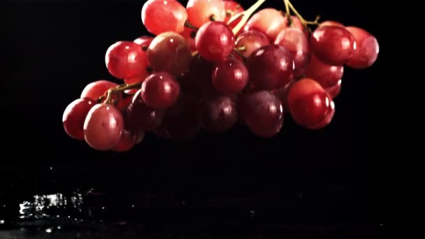 Een takje druiven valt op het water met spatten. Gefilmd is slow motion 1000 fps. — Stockvideo