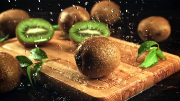 En el kiwi gotas de agua caen sobre la tabla de cortar. Filmado en cámara lenta 1000 fotogramas por segundo. — Vídeos de Stock