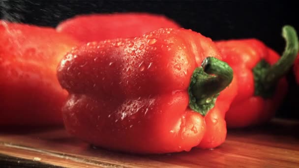 Water droplets fall on the pepper on the cutting board. Filmed is slow motion 1000 fps. — Stockvideo