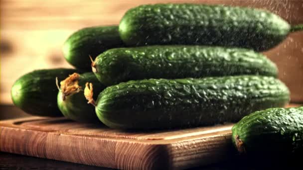 Drops of water fall on the cucumbers on the cutting board. Filmed is slow motion 1000 frames per second. — Stockvideo