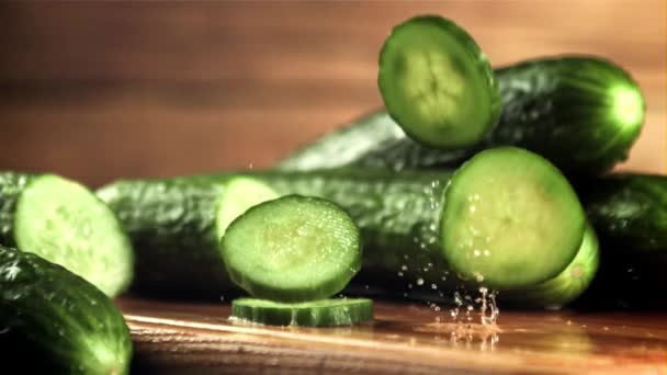 Gesnipperde verse komkommer valt op de tafel. Gefilmd is slow motion 1000 frames per seconde. — Stockvideo