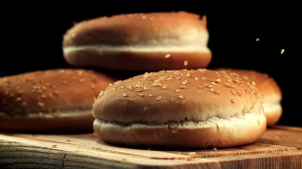 Sesam valt op hamburgerbroodjes. Gefilmd is slow motion 1000 frames per seconde. — Stockvideo