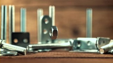 Metal fındıklar masaya düşer. Film yavaş çekimde 1000 fp..