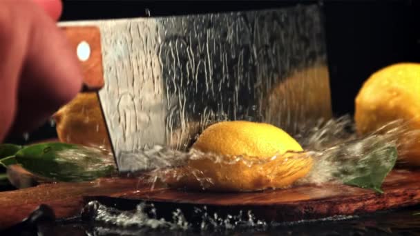 The lemon is cut into halves with a large knife. Filmed is slow motion 1000 fps. — Vídeo de Stock