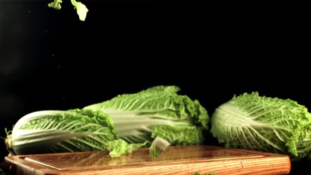 Pieces of Beijing cabbage fall on the cutting board.Filmed is slow motion 1000 frames per second. — Stock Video