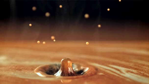 Een druppel valt in hete koffie met melk. Gefilmd is slow motion 1000 frames per seconde. — Stockvideo