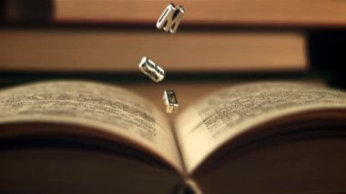 İngilizce harfler açık bir kitaba düşer. Saniyede 1000 kare yavaş çekimde çekiliyor..