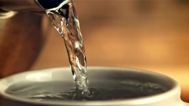 Gorąca woda jest wlewana do kubka po kawie. Nagrywane jest w zwolnionym tempie 1000 klatek na sekundę. — Wideo stockowe