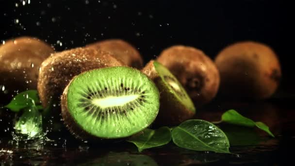 Splashes of water fall on the sliced kiwi. Filmed is slow motion 1000 frames per second. — Stockvideo