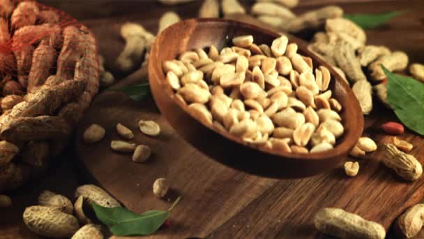 A wooden plate of peanuts falls on the table. Filmed is slow motion 1000 frames per second. — Stockvideo