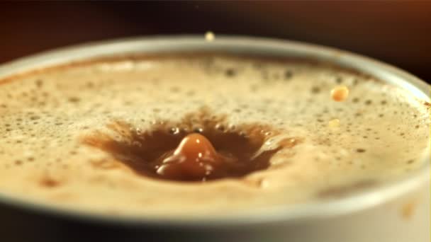 A drop of foam falls into a cup of coffee. Filmed is slow motion 1000 frames per second. — Stock video