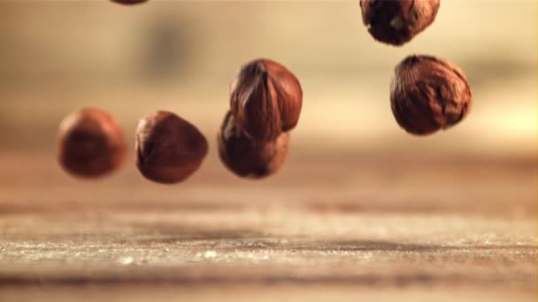 Peeled hazelnuts fall on the table. Filmed is slow motion 1000 fps. — Stock video