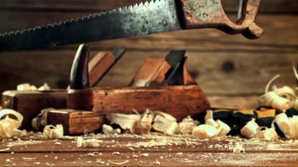 A saw falls on a table with sawdust. Filmed is slow motion 1000 frames per second. — Videoclip de stoc