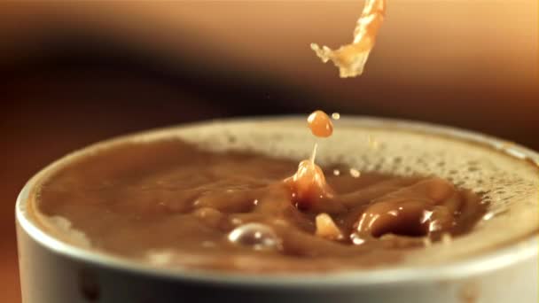 Σταγόνες πέφτουν στον καφέ με γάλα με πιτσιλίδια.Filmed είναι αργή κίνηση 1000 καρέ ανά δευτερόλεπτο. — Αρχείο Βίντεο