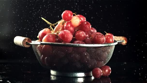 Drops of water fall on the grapes in the colander. Filmed is slow motion 1000 fps. — Stock video