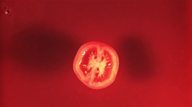 Bir parça domates suyu sıçramış domates suyuna düşer. 1000 fps hızla yüksek hızlı bir kamerayla çekildi..