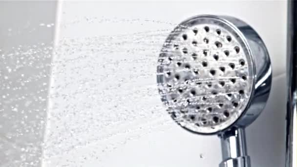 Una corriente de agua vierte desde el cabezal de la ducha. Filmado en cámara lenta 1000 fps. — Vídeo de stock