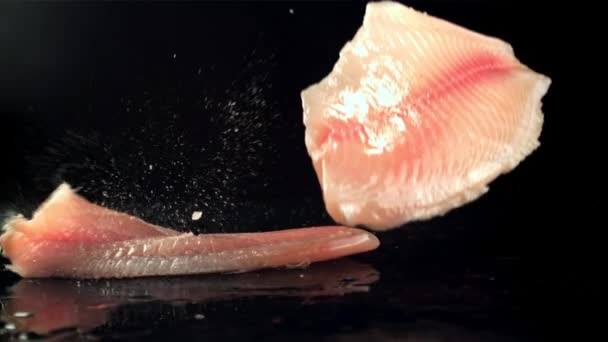 Los filetes de pescado caen sobre la mesa con salpicaduras de agua. Filmado en cámara lenta 1000 fps. — Vídeos de Stock