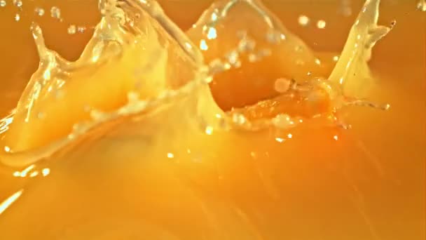 오렌지 덩어리들 이 물보라와 함께 오렌지 주스 속으로 떨어진다. 고속 카메라에 촬영 1000 fps. — 비디오