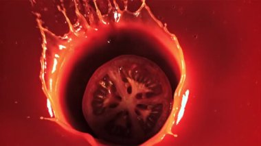 Su damlatan bir domates parçası domates suyuna düşer. 1000 fps hızla yüksek hızlı bir kamerayla çekildi..