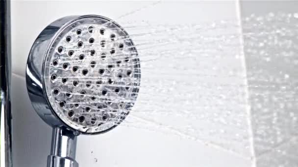 Una corriente de agua vierte desde el cabezal de la ducha. Filmado en cámara lenta 1000 fps. — Vídeos de Stock