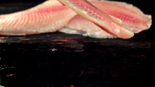 魚の切り身は水でテーブルの上に落ちる。撮影はスローモーション1000 fps. — ストック動画