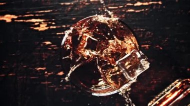 Su damlatan buz bir bardak viskinin içine düşer. Üst Manzara. 1000 fps hızla yüksek hızlı bir kamerayla çekildi..