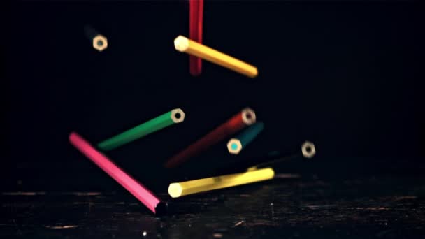 Na stůl padají barevné tužky. Film je zpomalený 1000 fps. — Stock video