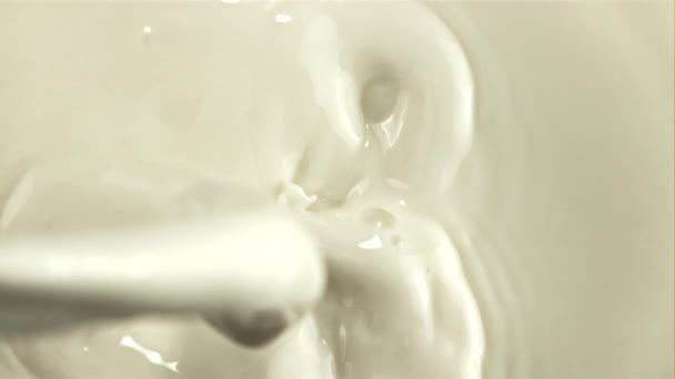 Un flusso di latte fresco si riversa dentro con spruzzi. Girato su una telecamera ad alta velocità a 1000 fps. — Video Stock