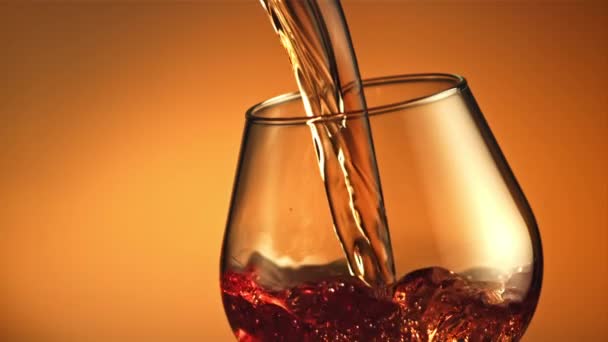 Cognac stroomt in een beekje met luchtbellen in het glas. Gefilmd is slow motion 1000 fps. — Stockvideo