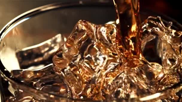 A jet of whiskey with splashes flows into a glass of ice.Filmed is slow motion 1000 fps. — Stock Video