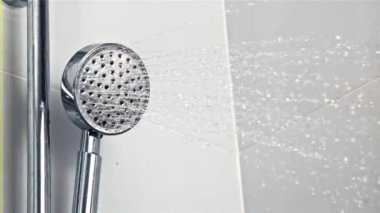 Duş başlığından dökülen su damlaları. 1000 fps hızla yüksek hızlı bir kamerayla çekildi..