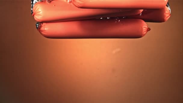 Korv faller i vattnet med luftbubblor. Inspelning på en höghastighetskamera vid 1000 fps. — Stockvideo