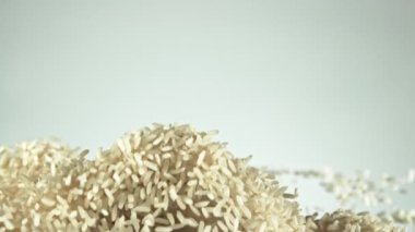 Pirinç yükselir ve aşağı düşer. Beyaz bir arka planda. Film yavaş çekimde 1000 fp..