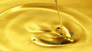 Bir jet zeytinyağı hava kabarcıklarıyla doluyor. Makro arka plan. Film yavaş çekimde 1000 fp..