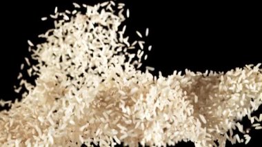 Bir pirinç yığını yükselir ve düşer. Siyah bir arka planda. 1000 fps hızla yüksek hızlı bir kamerayla çekildi..