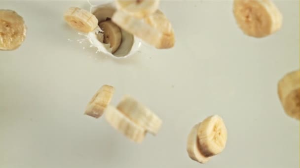 Scheiben Geschnittene Banane Fällt Mit Spritzern Milch Ansicht Von Oben — Stockvideo
