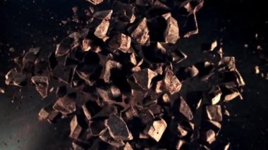 Çikolata parçaları uçarken uçar ve dönüşümlü olarak uçar. Üst Manzara. Film yavaş çekimde 1000 fp..