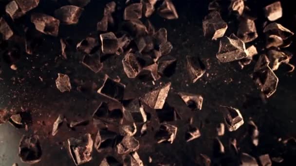 Куски Шоколада Взлетают Вращаются Полете Вид Сверху Темном Фоне Замедленная — стоковое видео