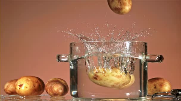 Fresh Unpeeled Potatoes Fall Pot Water Splashes Pink Background Filmed — Stock Video